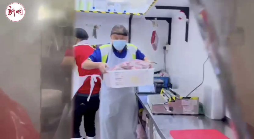 Lim Hock Chee stacking his shelves and carrying out the pork when his staff fell sick with COVID: Source - Shin Min News